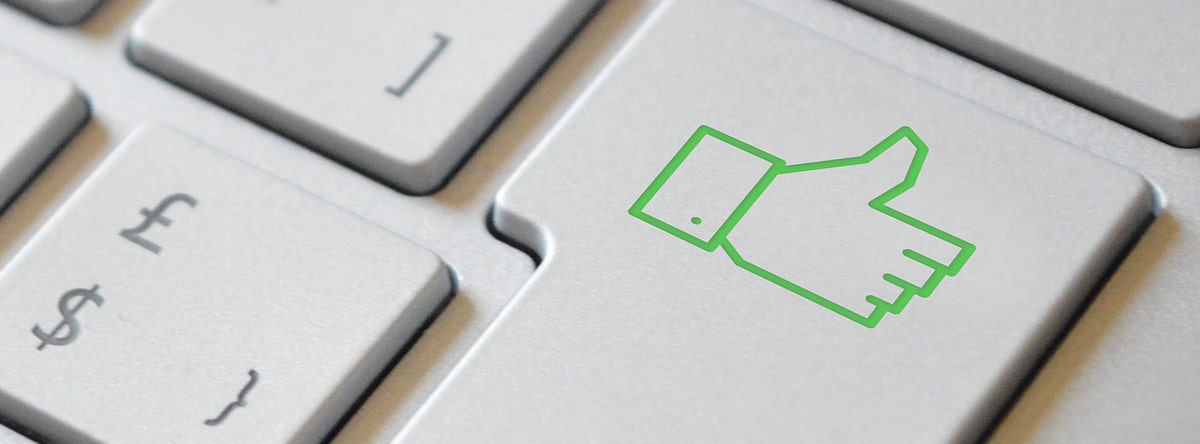 A close up of a green thumbs up sign on a keyboard.