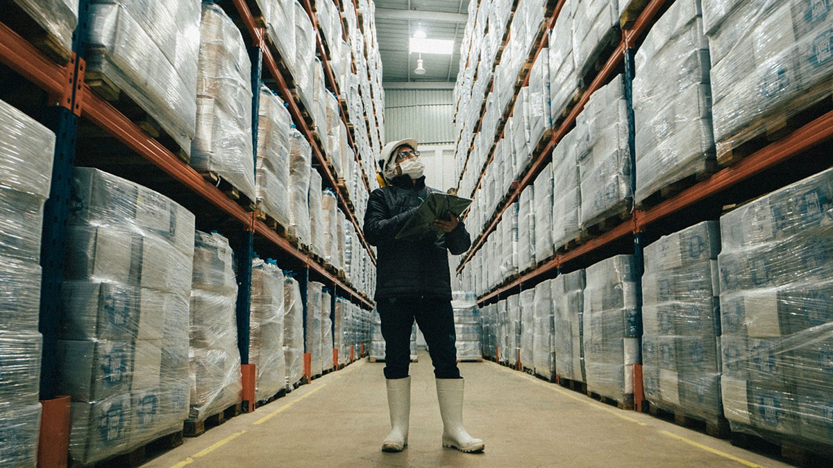 A worker in a warehouse holding a tablet.