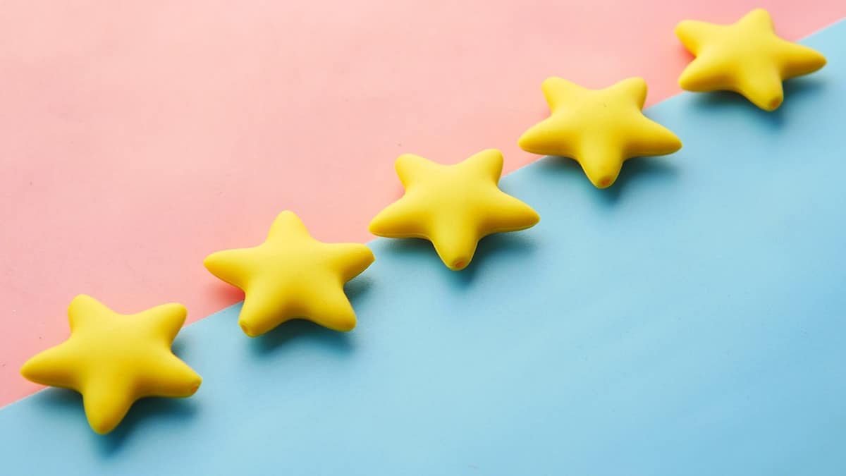 Five yellow stars on a pink and blue background.