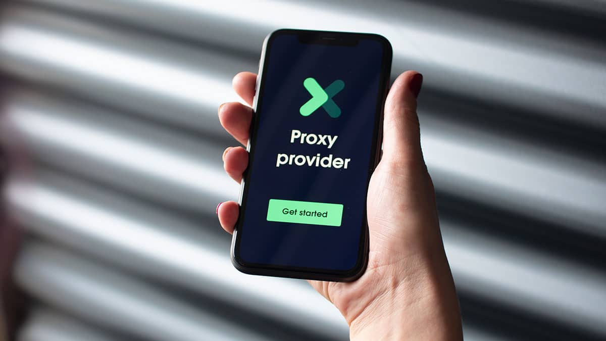 A person holding up a smartphone with the word proxy provider on it.