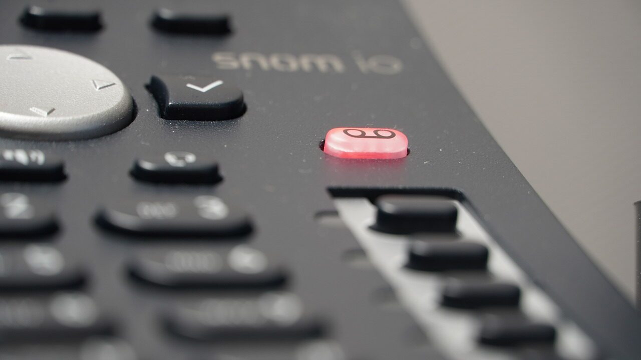A close up of a phone with a red button.