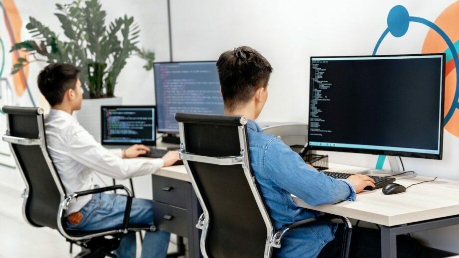 Two men working on computers in an office.