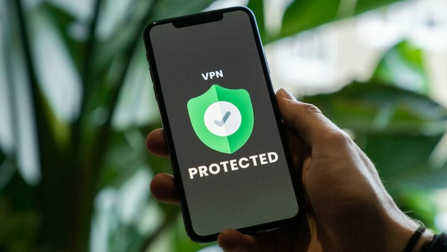 A person holding up a phone with the word vpn protected on it.