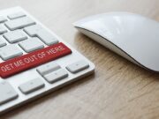 A computer keyboard with a red button that says get me out of here.
