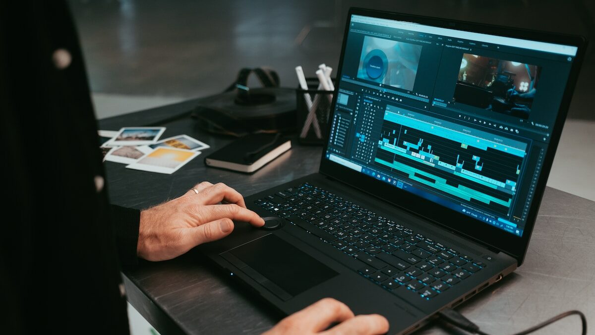 A man is using a laptop to edit a video.